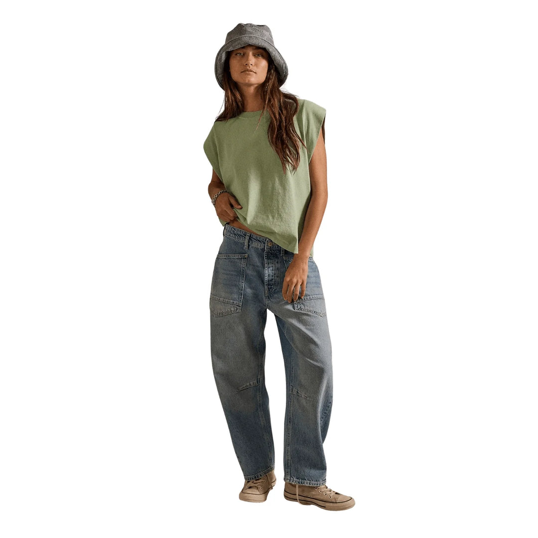 Full-length front studio view of a model styled in a bucket hat, green sleeveless tee, and the Free People We the Free Minimalist Moxie Barrel Jeans in County Fair | Twentyseven