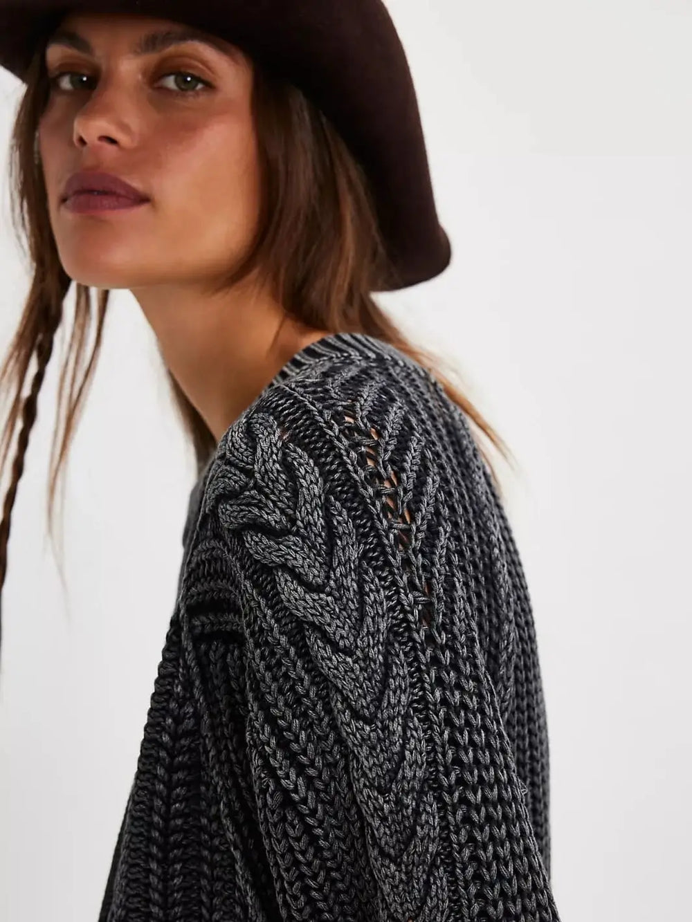 A close-up side view showcases the intricate chevron and open-stitch cable patterns along the shoulder and sleeve of the Free People Frankie Cable Sweater in Black | Twentyseven Toronto