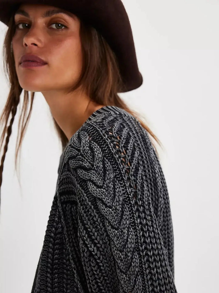 A close-up side view showcases the intricate chevron and open-stitch cable patterns along the shoulder and sleeve of the Free People Frankie Cable Sweater in Black | Twentyseven Toronto