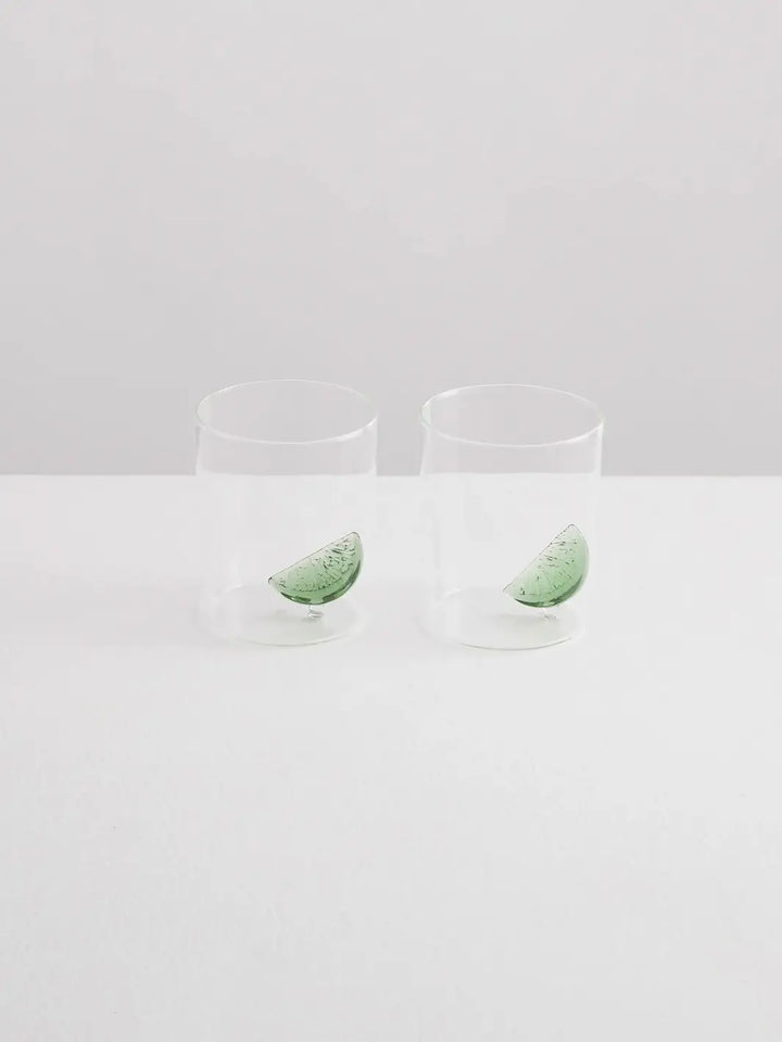 Two clear gin and tonic gobelets with glass lime wedges from Maison Balzac on a white background | Twentyseven Toronto