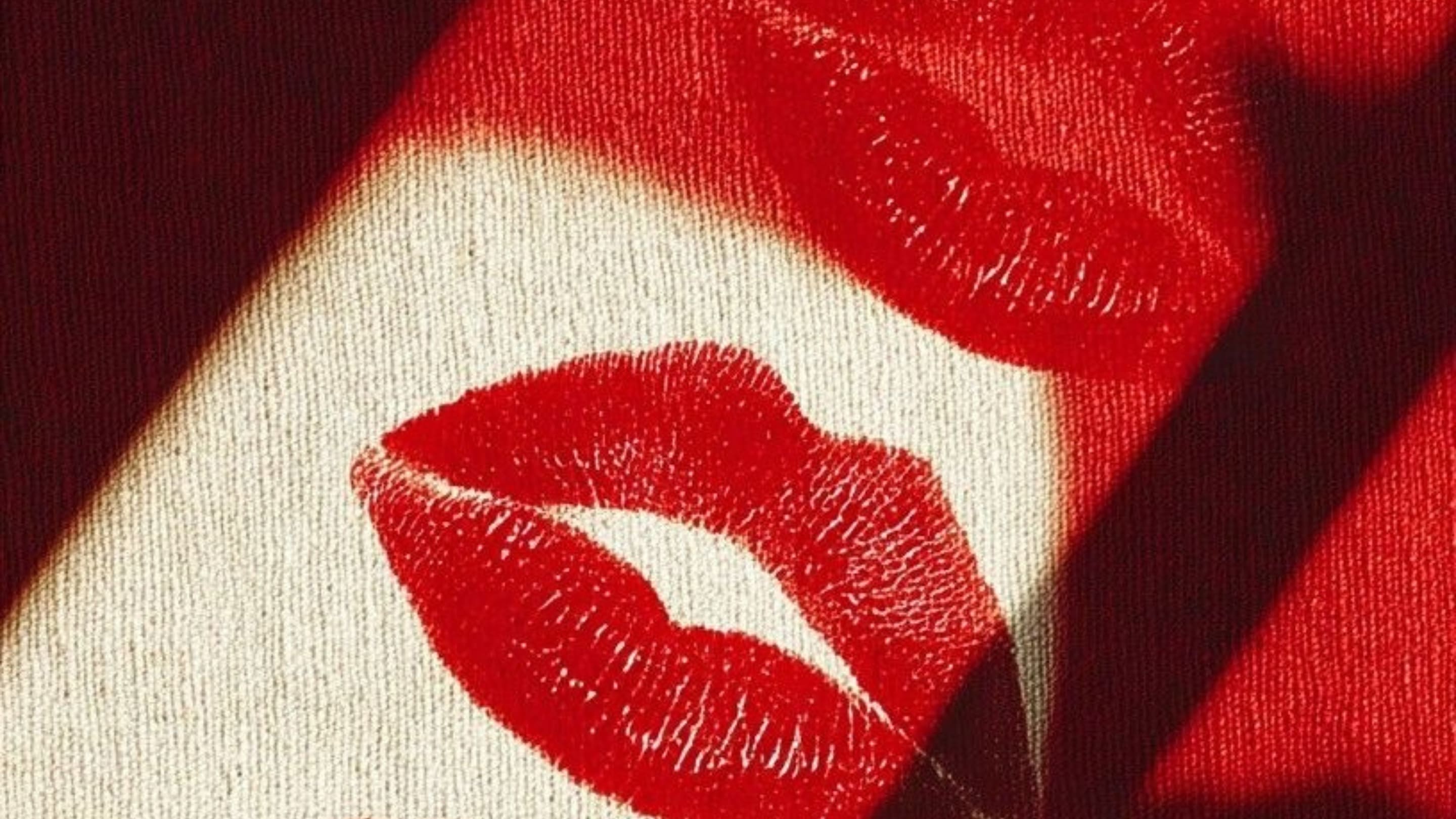 Close-up of red lips printed on fabric with shadows