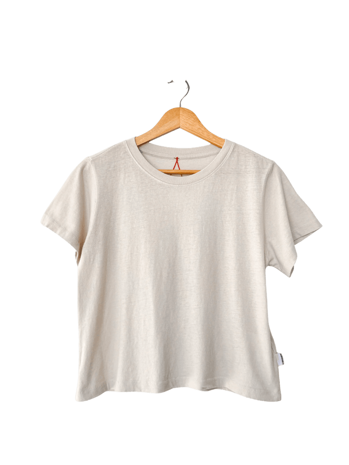 A studio product shot of the Le Bon Shoppe Airy Darling Tee in Rice displayed on a wooden hanger | Twentyseven