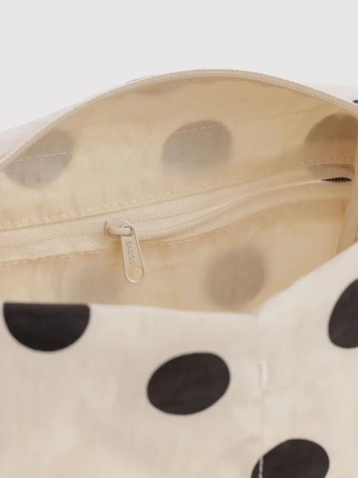 A close-up shot showing the cream-colored interior lining and zippered pocket of the BAGGU Dopp Kit in Cream and Black Polka Dot | Twentyseven