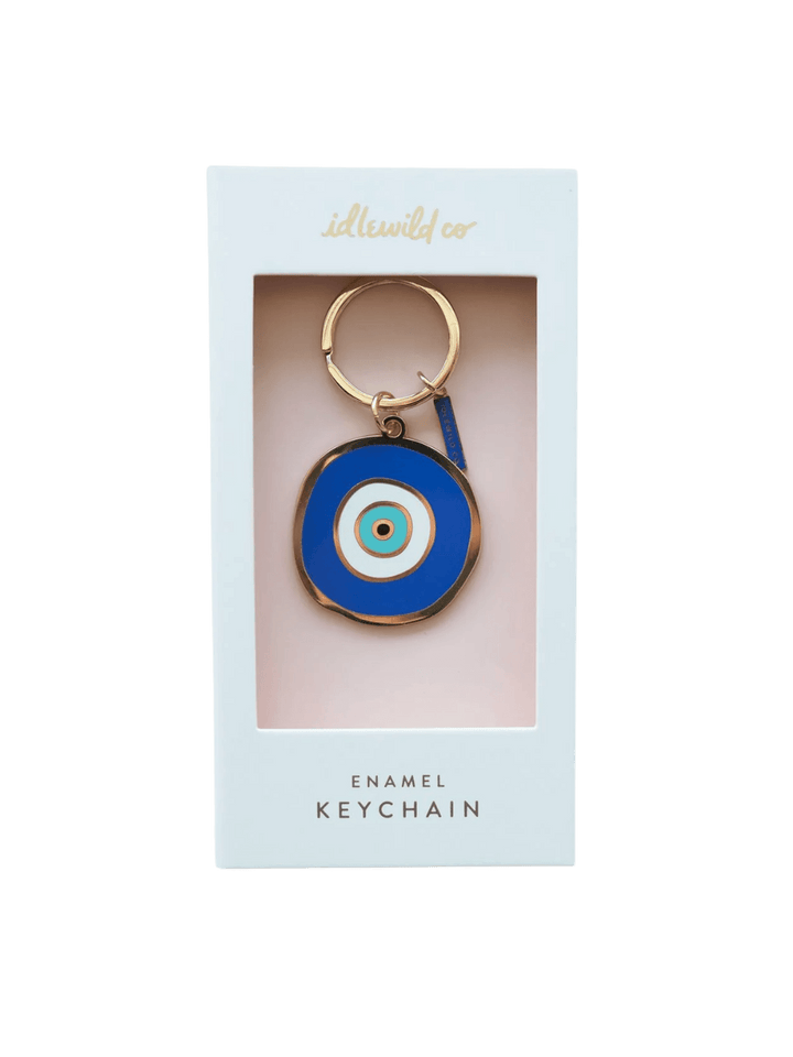 A front-facing studio shot of the Idlewild Co. Evil Eye Enamel Keychain in its original white display packaging | Twentyseven