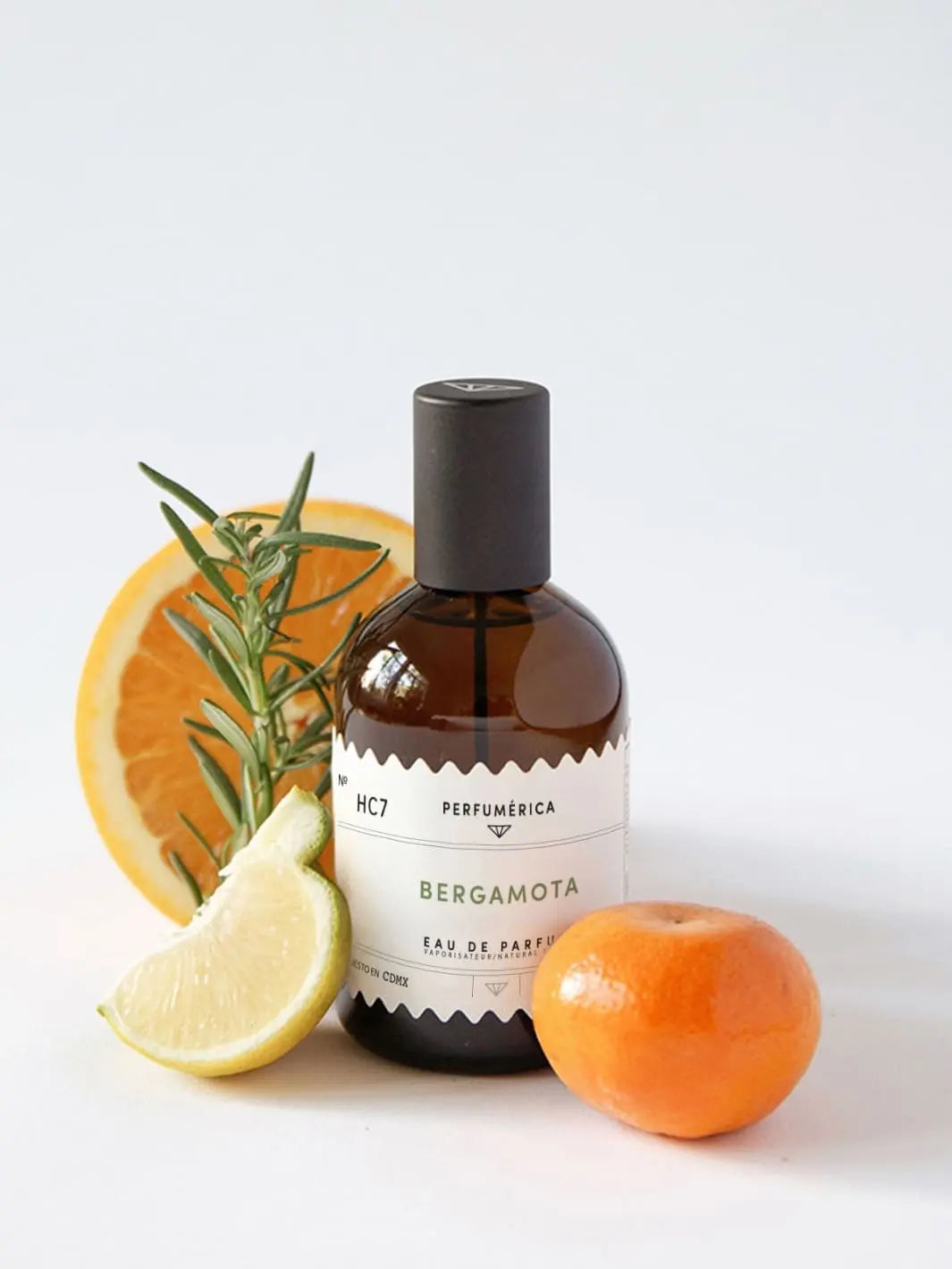 Brown perfume bottle with a black cap, the fragrance 'HC7 Bergamot Eau de Parfum' from Perfumérica, 120ml, with citrus fruits on a white background | Twentyseven Toronto