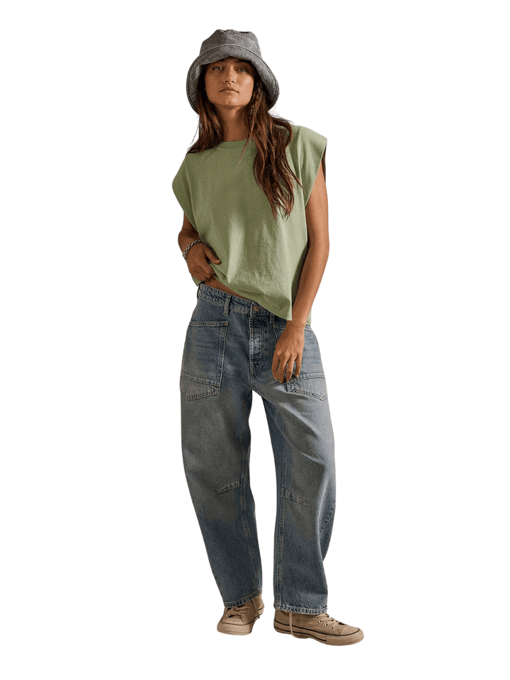 Full-length front studio view of a model styled in a bucket hat, green sleeveless tee, and the Free People We the Free Minimalist Moxie Barrel Jeans in County Fair | Twentyseven