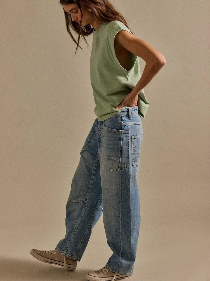 Full-length side profile view of a model wearing the relaxed-fit Free People We the Free Minimalist Moxie Barrel Jeans in County Fair paired with sneakers | Twentyseven