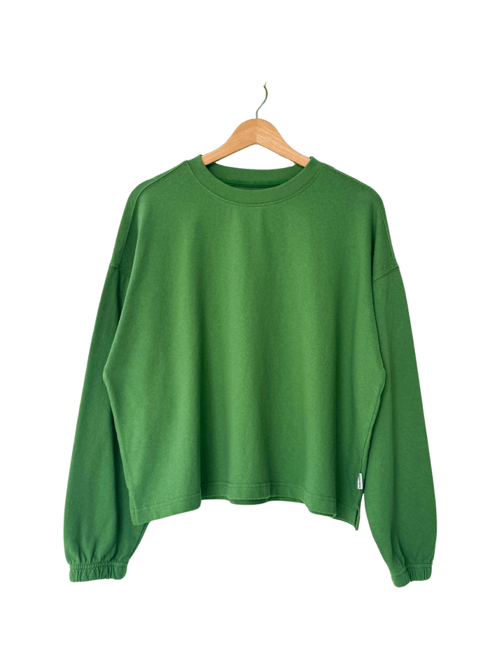 studio product shot of the long-sleeve Le Bon Shoppe Naturelle Tee in Asparagus hanging on a wooden hanger | Twentyseven