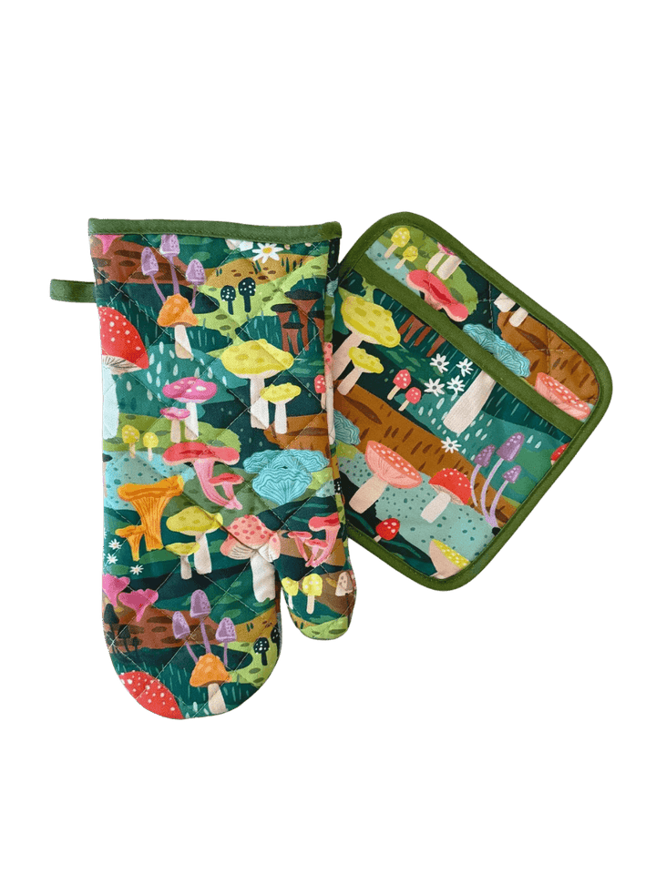 A studio product shot of the Idlewild Co. Oven Mitt + Potholder Set in Mushroom Heaven featuring a matching forest green oven mitt and potholder decorated with a colourful illustrated mushroom pattern | Twentyseven