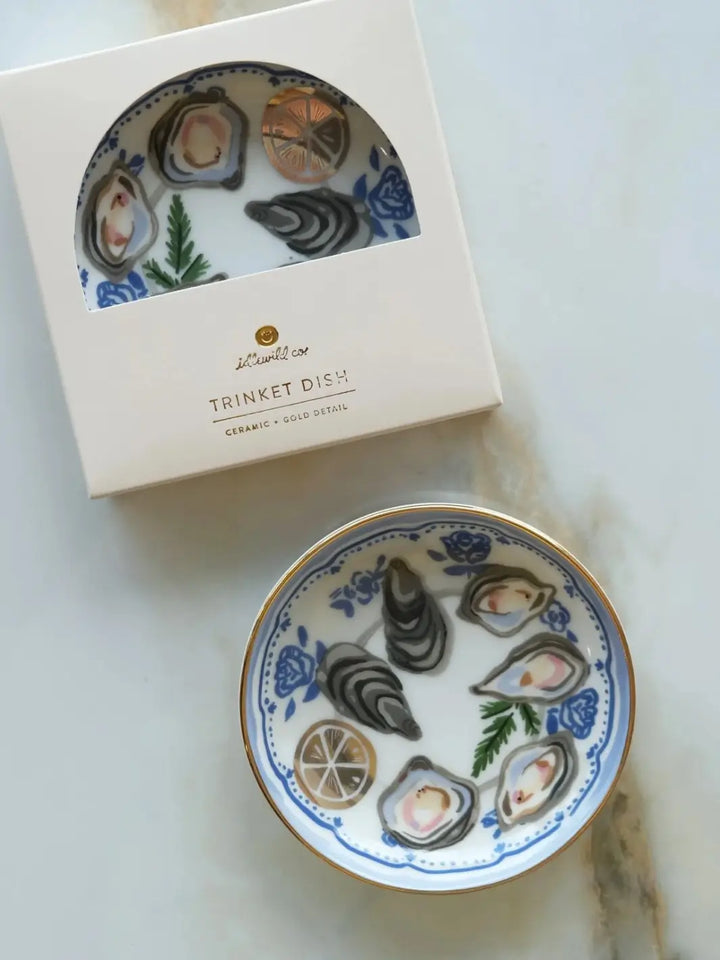 The Idlewild Co. Oysters Porcelain Trinket Dish displayed next to its original white window-cut packaging box on a light marble background | Twentyseven