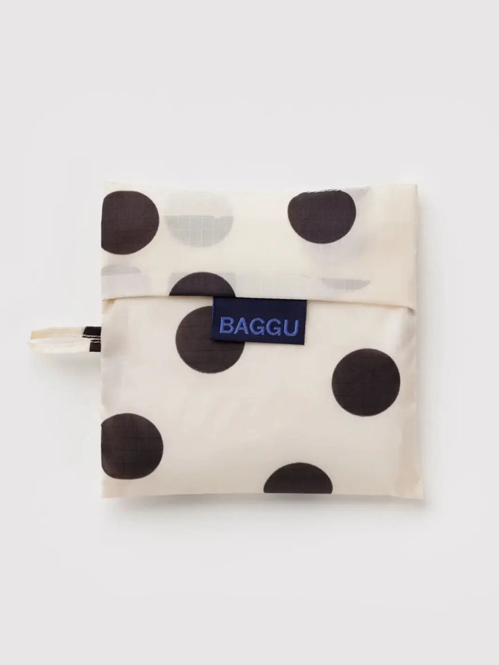 A top-down shot of the BAGGU Standard Baggu in Cream and Black Polka Dot folded into its matching square pouch | Twentyseven