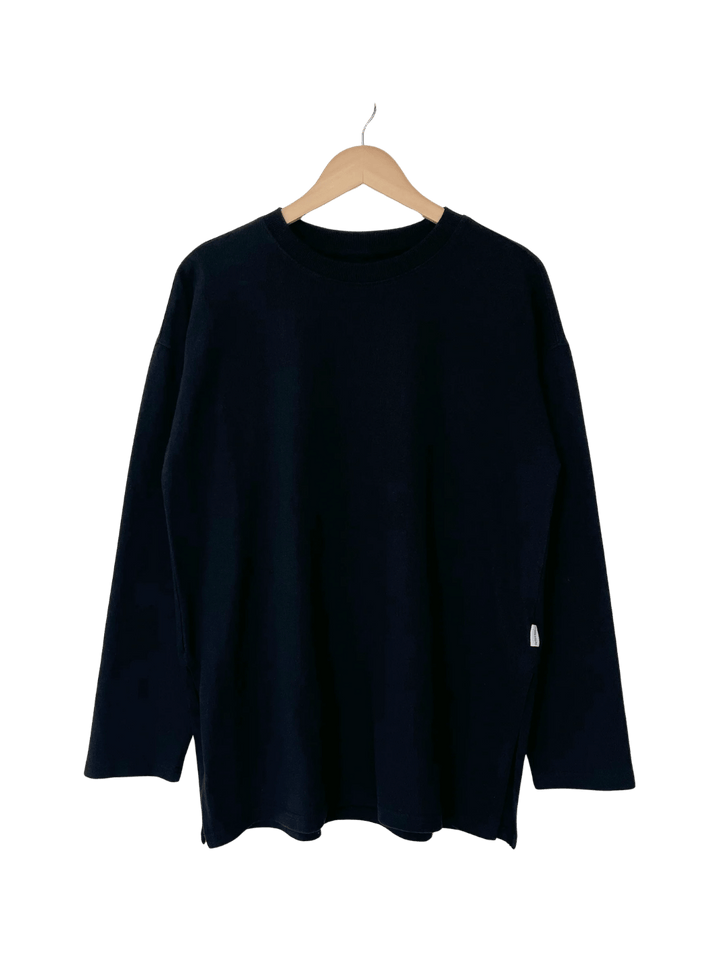 A studio product shot of the dark long-sleeve Le Bon Shoppe Sunday Tee in Black displayed on a wooden hanger | Twentyseven