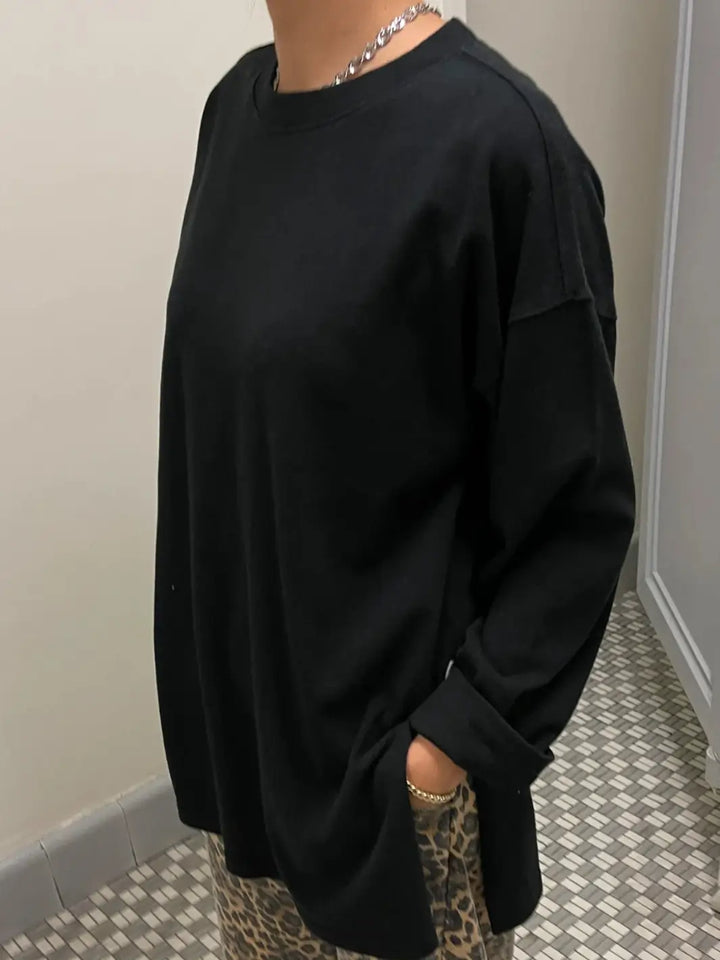 A close-up side angle of a model wearing the Le Bon Shoppe Sunday Tee in Black paired with leopard print pants and a silver chain necklace | Twentyseven