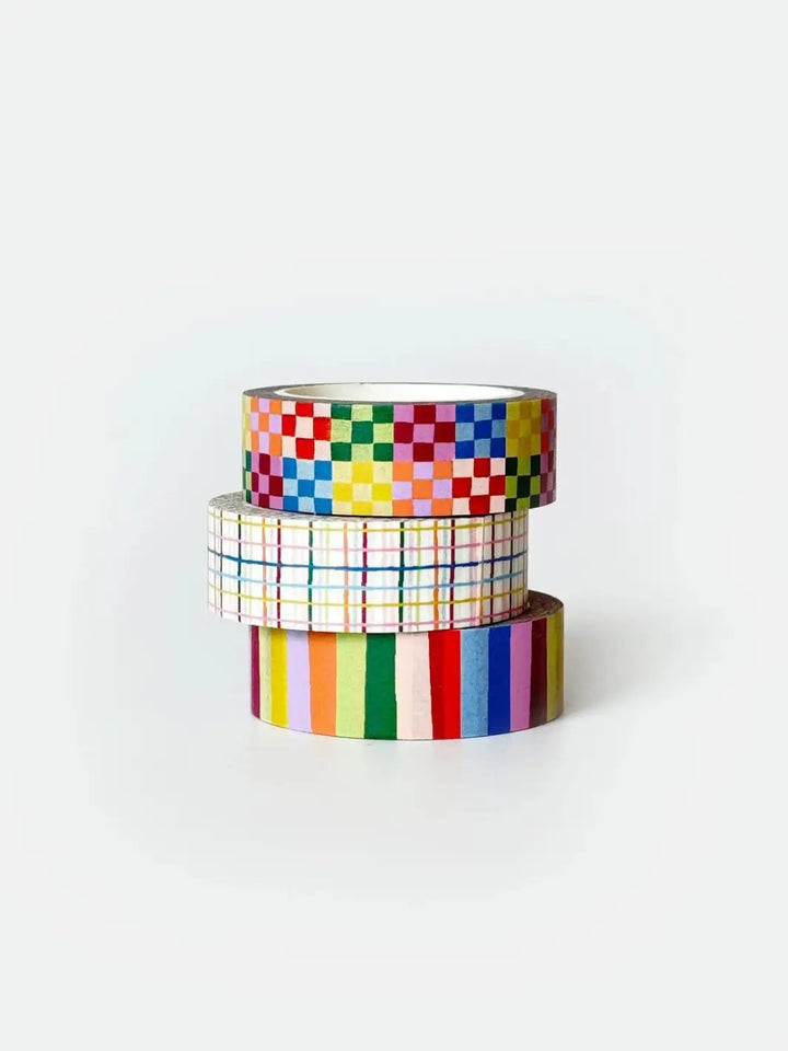 A neatly stacked trio of the Idlewild Co. Washi Tape, Set of 3 in Rainbow rolls showcasing the vibrant multicolored checkered, plaid, and bold striped patterns | Twentyseven