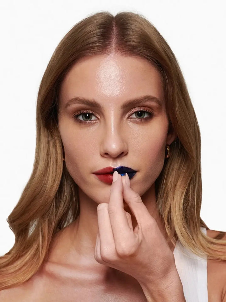 A woman peeling off the metallic blue film to reveal the deep rose shade of the Wonderskin WONDER BLADING Peel & Reveal Lip Color Kit in Charming | Twentyseven