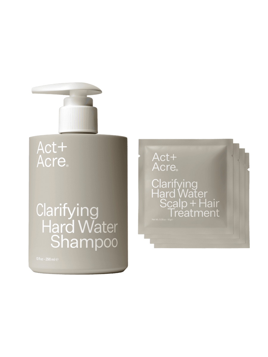 Act+Acre Clarifying Hard Water Shampoo bottle and Clarifying Hard Water Scalp and Hair Treatment sachets on a transparent background | Twentyseven Toronto