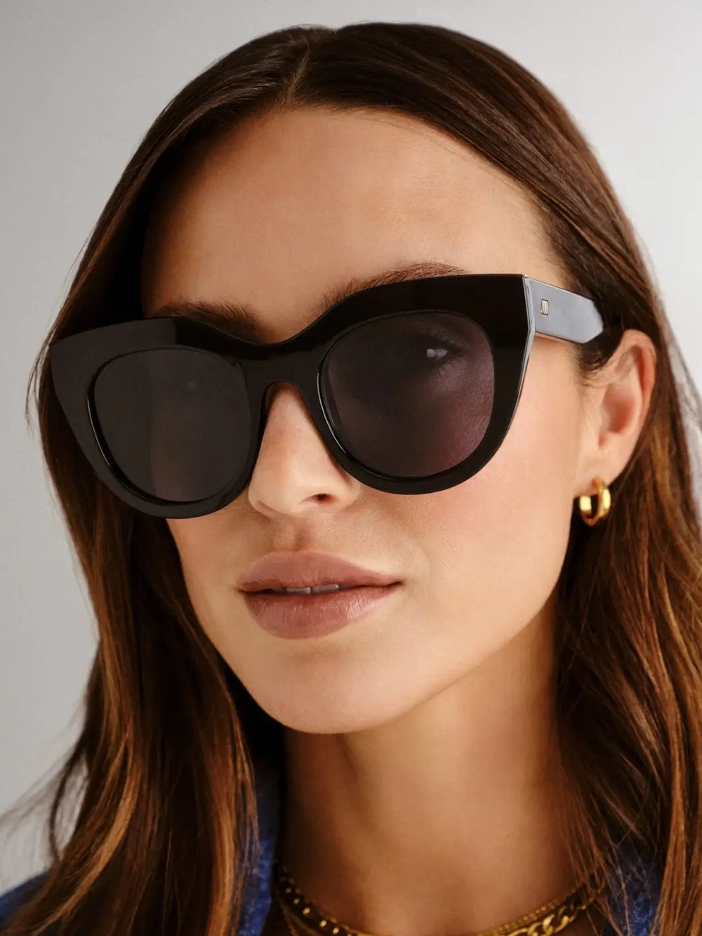 A woman wearing oversized, thick-rimmed Le Specs Air Heart - Black sunglasses | Twentyseven Toronto
