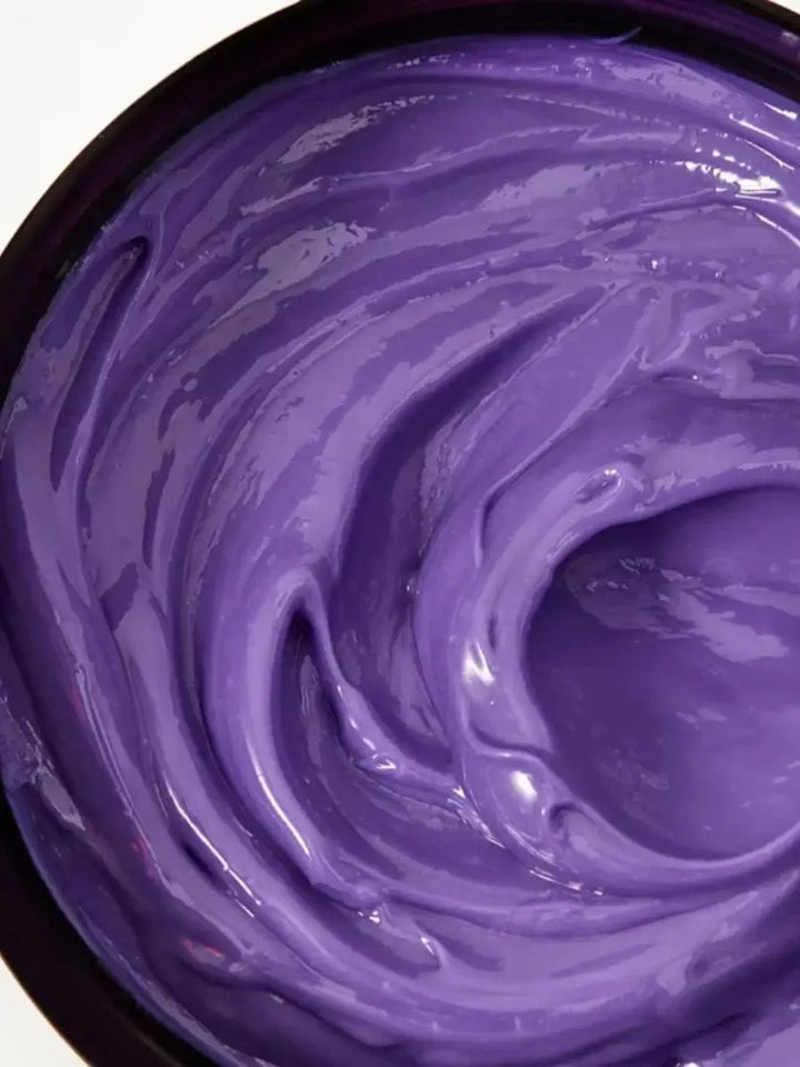 A close-up view shows the thick, swirled purple cream inside a tub of Davines ALCHEMIC Silver Conditioner | Twentyseven Toronto