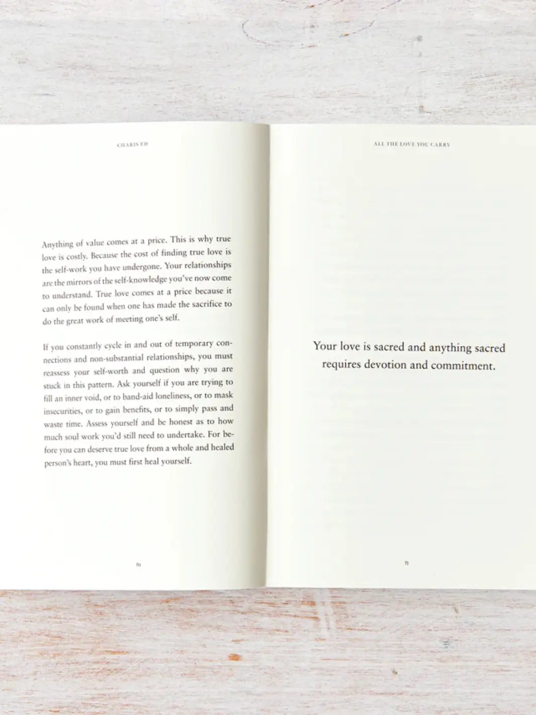An open spread of All The Love You Carry by Charis Ed features deep reflections on self-worth and relationships opposite the bold statement, "Your love is sacred and anything sacred requires devotion and commitment." | Twentyseven Toronto
