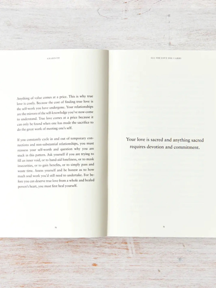 An open spread of All The Love You Carry by Charis Ed features deep reflections on self-worth and relationships opposite the bold statement, "Your love is sacred and anything sacred requires devotion and commitment." | Twentyseven Toronto