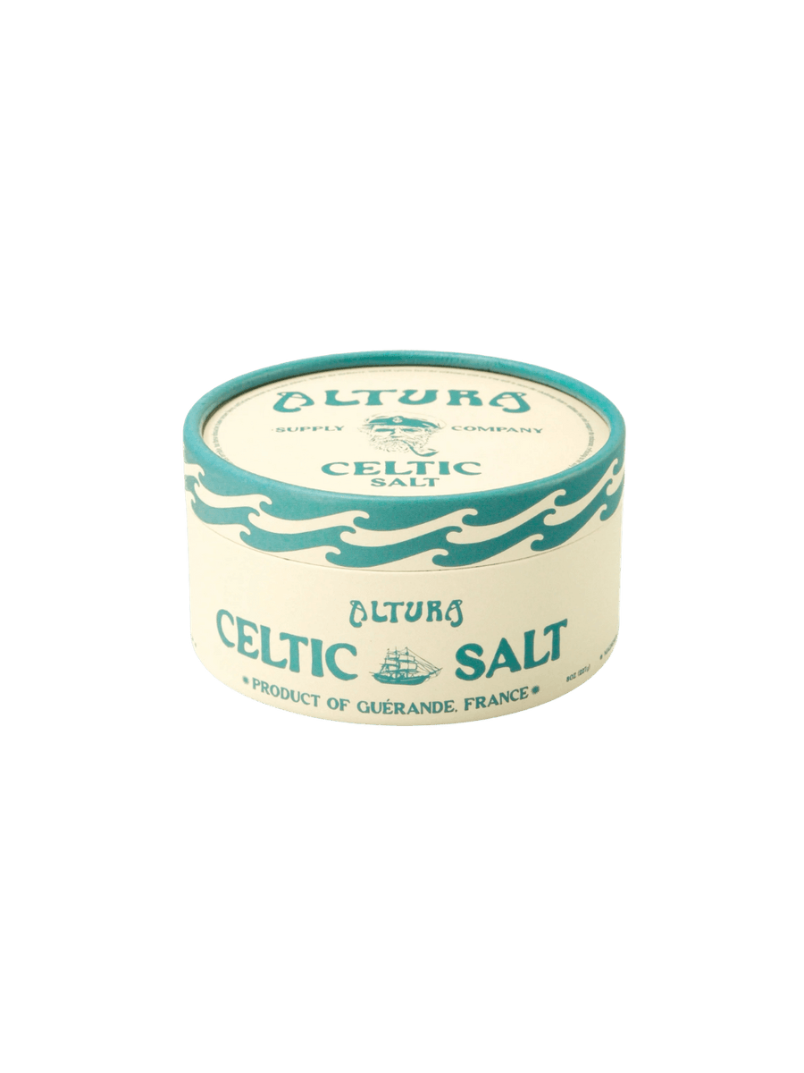 Eco-friendly paper tube of Altura Celtic Sea Salt highlighting its teal wave pattern and "Product of Guérande, France" label on a transparent background | Twentyseven Toronto