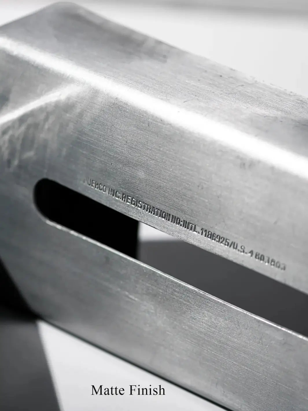 Close-up view on the industrial matte finish and the small stamped registration text running above the opening of the Aluminum Tissue Case from Puebco | Twentyseven Toronto