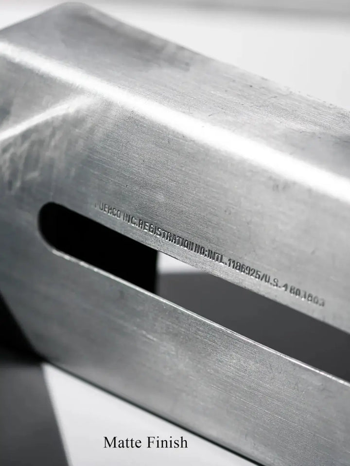 Close-up view on the industrial matte finish and the small stamped registration text running above the opening of the Aluminum Tissue Case from Puebco | Twentyseven Toronto