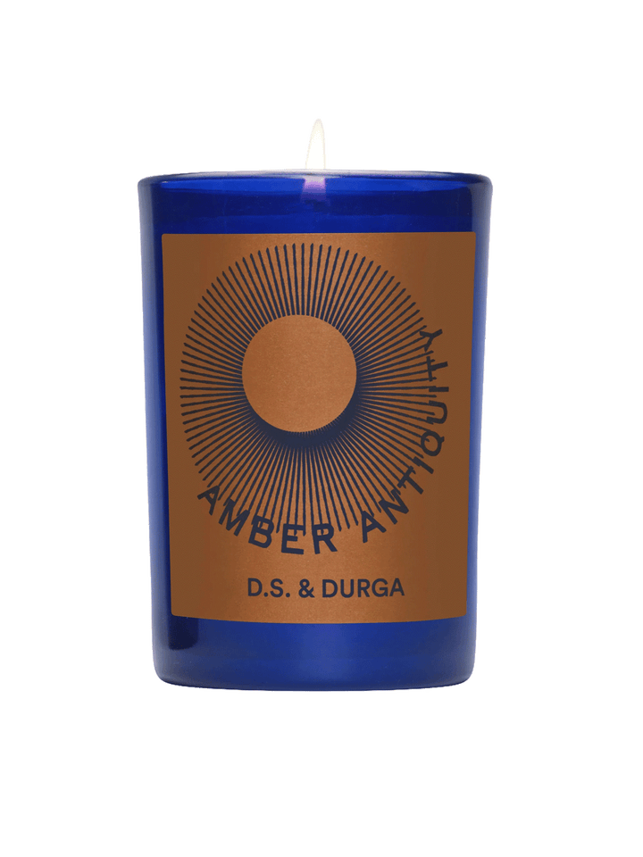 D.S. & Durga Amber Antiquity Candle in a cobalt blue glass vessel with amber and navy graphic label | Twentyseven Toronto