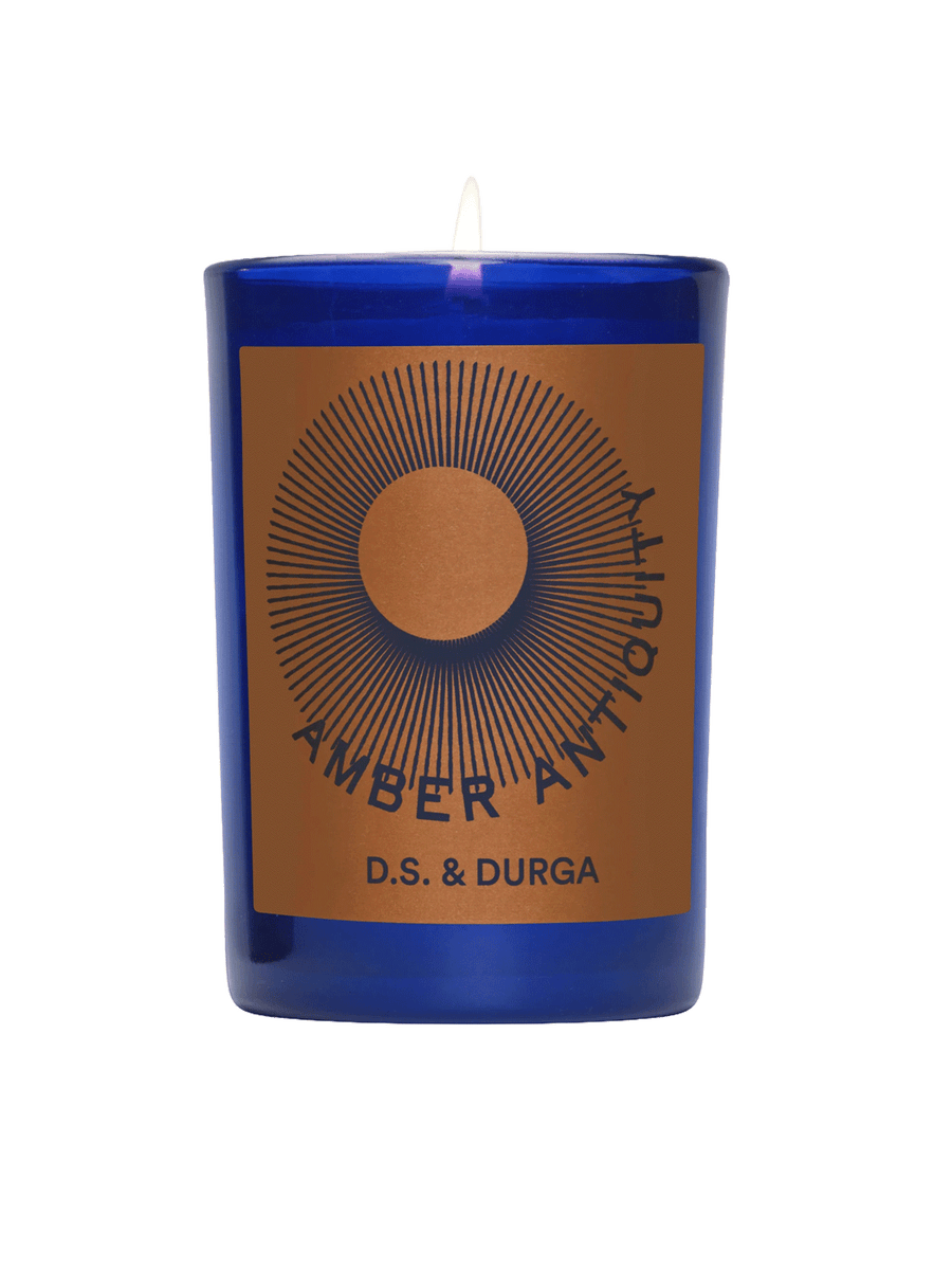D.S. & Durga Amber Antiquity Candle in a cobalt blue glass vessel with amber and navy graphic label | Twentyseven Toronto