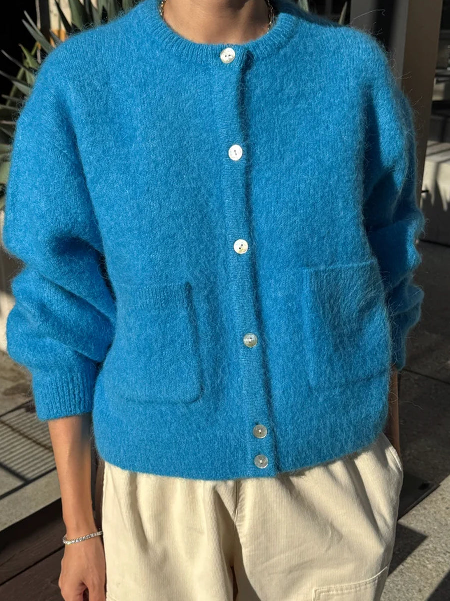 Model wearing the Le Bon Shoppe Amelie Cardigan in turquoise blue with cream trousers, showing its relaxed fit, soft fuzzy knit and front patch pockets | Twentyseven Toronto