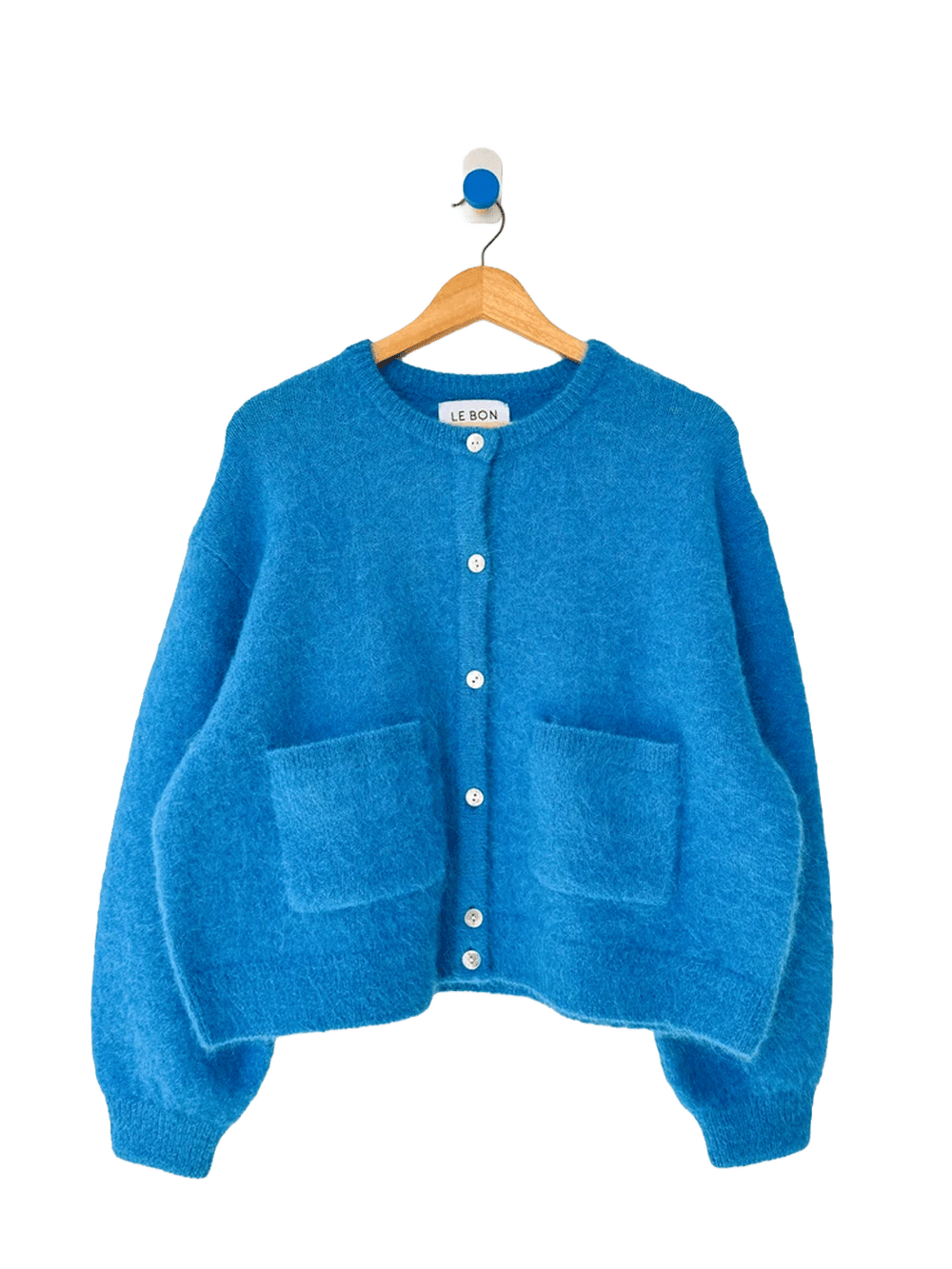 Turquoise blue Le Bon Shoppe Amelie Cardigan on a wooden hanger, featuring a fuzzy knit texture, button front, crew neckline and two patch pockets | Twentyseven Toronto