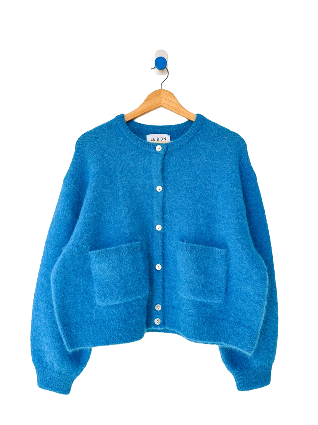 Turquoise blue Le Bon Shoppe Amelie Cardigan on a wooden hanger, featuring a fuzzy knit texture, button front, crew neckline and two patch pockets | Twentyseven Toronto