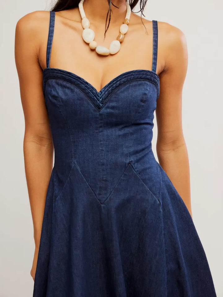 A close-up shot focusing on the sweetheart neckline, structured bodice, and detailed stitching of the Free People Another Season Denim Midi Dress in Rinse | Twentyseven Toronto