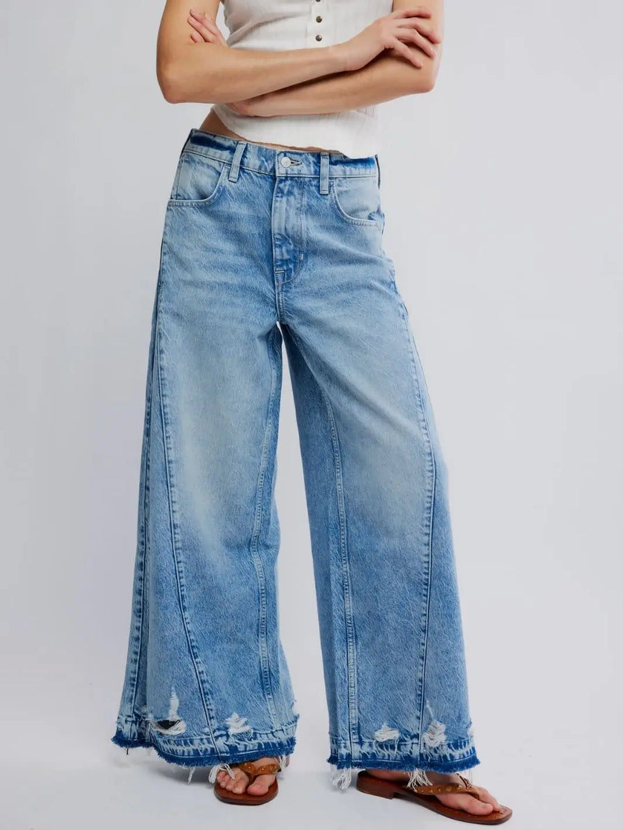 A studio front view showcases the dramatic wide-leg fit and heavily frayed, distressed hems of the Free People Apollo Wide Leg in Streamline | Twentyseven Toronto