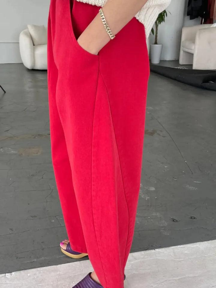 A side profile view highlights the unique barrel-leg seam detail and deep side pockets of the bright red Le Bon Shoppe Arc Pants in Crayon Red | Twentyseven Toronto