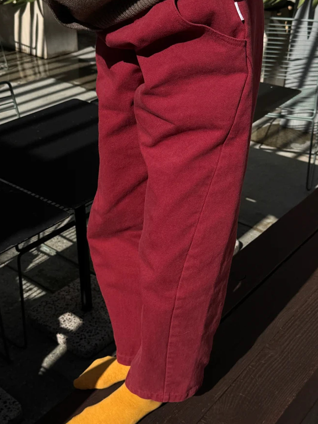 Side view of model wearing Le Bon Shoppe Arc Pants in Oxblood, showing the curved pocket and seam detailing | Twentyseven Toronto