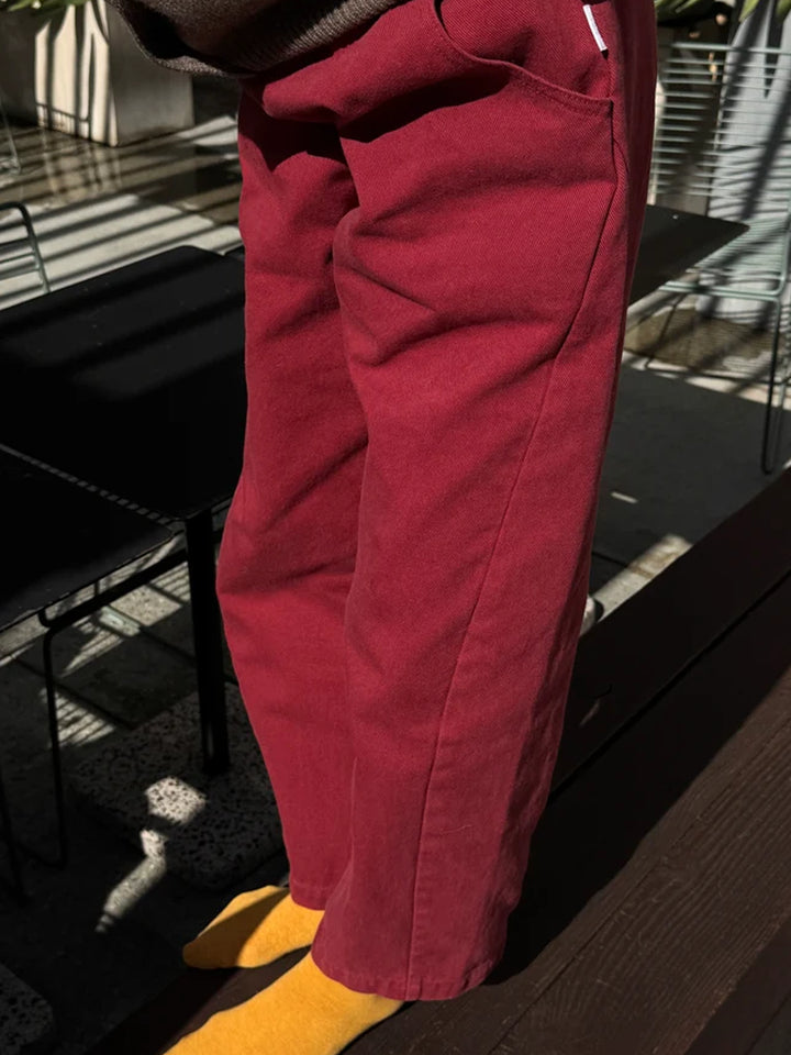Side view of model wearing Le Bon Shoppe Arc Pants in Oxblood, showing the curved pocket and seam detailing | Twentyseven Toronto