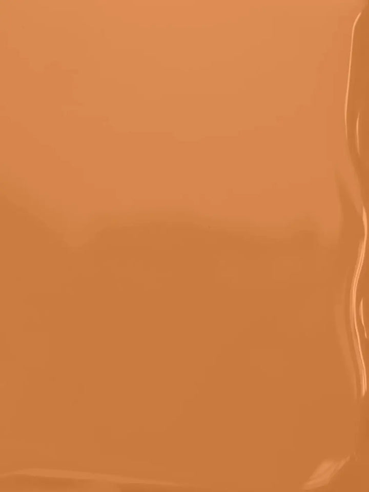 A full-frame texture shot showing the smooth, glossy, liquid surface of the warm caramel-brown BKIND Nail Polish in Val-d'Or formula | Twentyseven Toronto