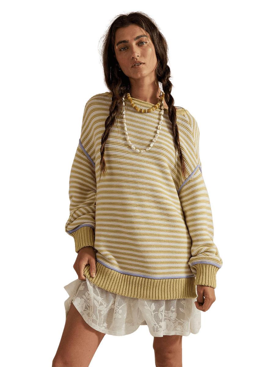 A model with braided dark hair standing in the slouchy Free People We the Free Asher Pullover in Sand Combo and a white lace mini skirt | Twentyseven Toronto