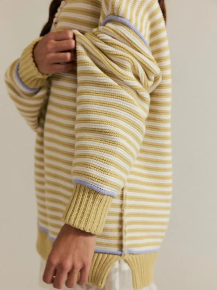 A close-up side angle details the thick ribbed cuffs, side slit hem, and textured knit pattern of the Free People We the Free Asher Pullover in Sand Combo | Twentyseven Toronto