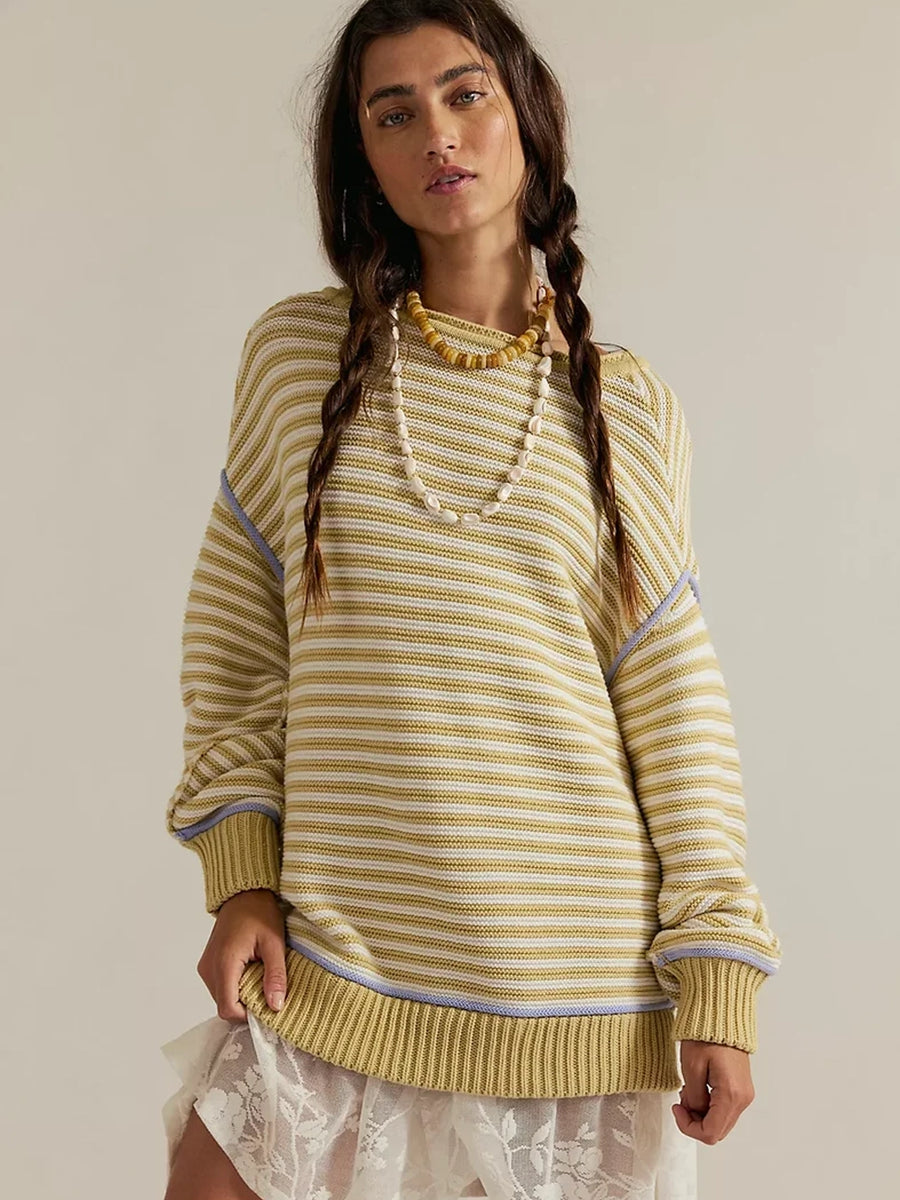 A model with braided dark hair standing in the slouchy Free People We the Free Asher Pullover in Sand Combo and a white lace mini skirt | Twentyseven Toronto