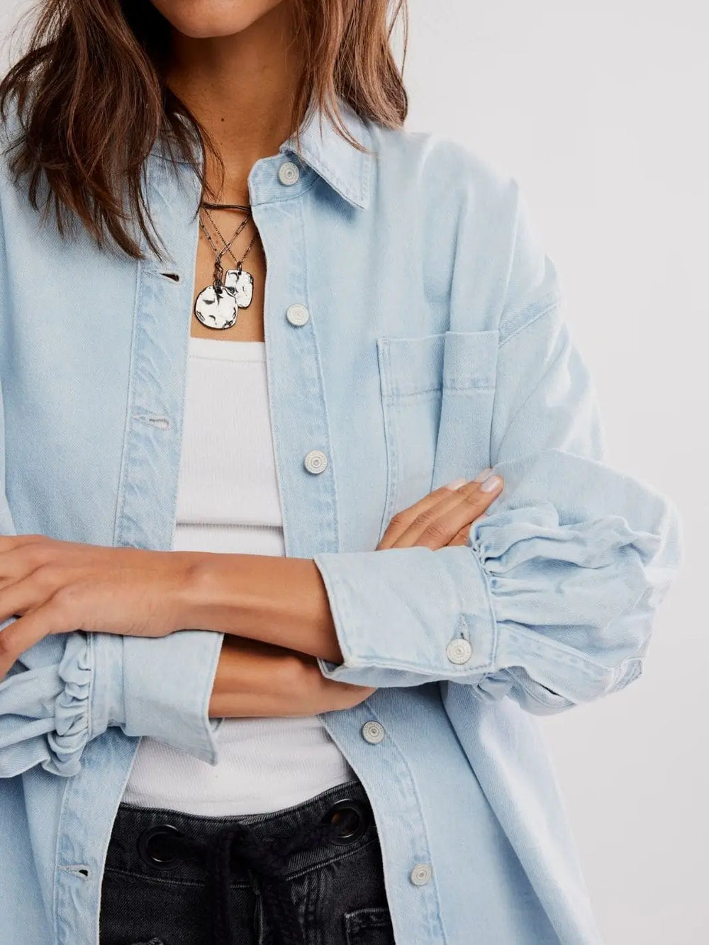 A close-up shot emphasizes the gathered cuff detailing, front button closures, and chest pocket of the Free People Ashley Denim Shirt - Classic Blue Wash | Twentyseven Toronto