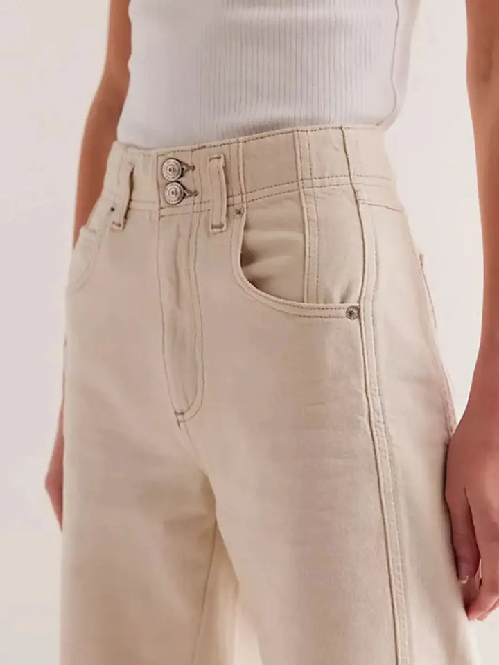 A close-up front view highlights the high-rise waistband with a double-button closure and panel detailing on the Free People Aster Straight-Leg Jeans - Cream | Twentyseven Toronto