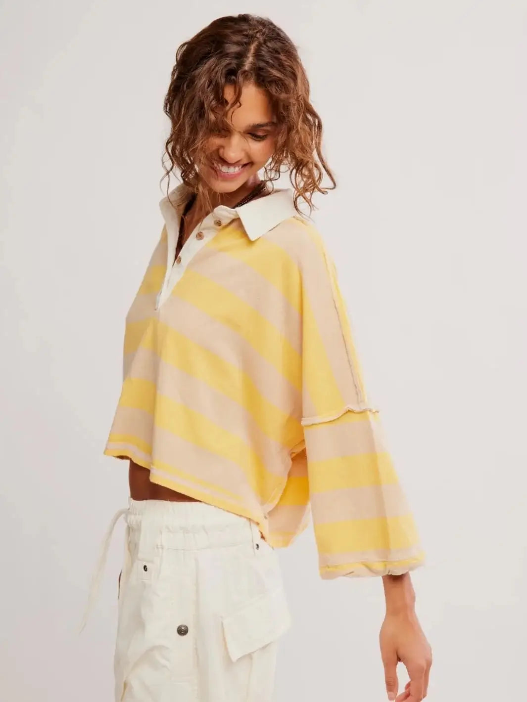 A side profile view highlights the relaxed silhouette and dropped shoulders of the striped Free People Auggie Tee in Oat Latte/Yellow Fin | Twentyseven Toronto