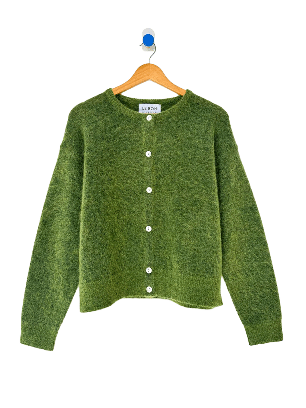 Le Bon Shoppe Ayla Cardigan in Artichoke hanging on a wooden hanger, featuring a soft, fuzzy green knit, round neckline, white buttons and long sleeves | Twentyseven Toronto