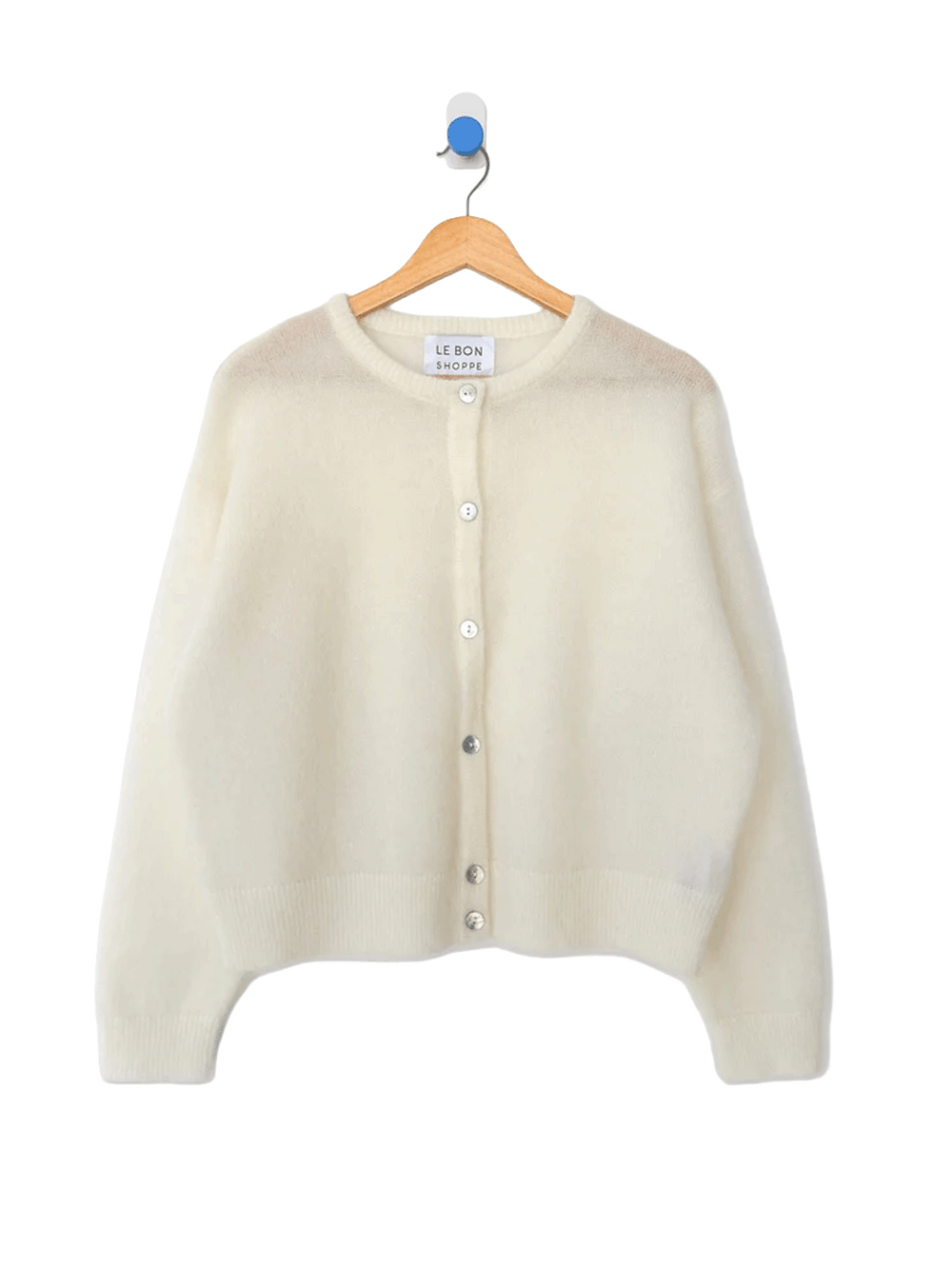 Le Bon Shoppe Ayla Cardigan in Pearl hanging on a wooden hanger, featuring a soft ivory fuzzy knit, round neckline, white buttons and long sleeves | Twentyseven Toronto