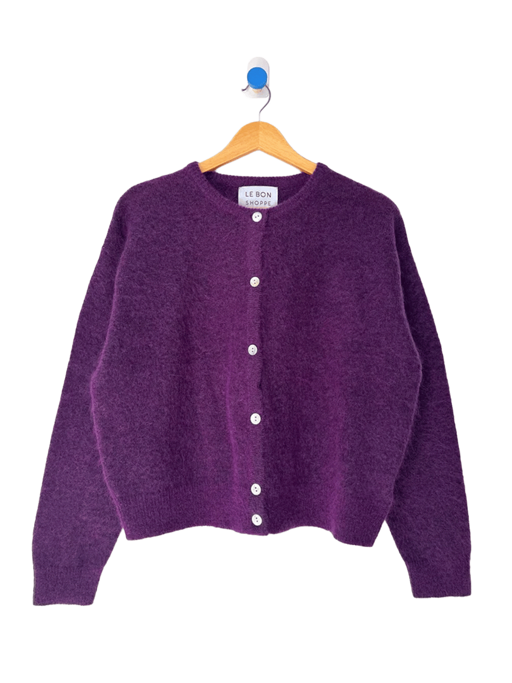 Le Bon Shoppe Ayla Mohair Cardigan in purple displayed on a wooden hanger, featuring a crew neckline and shell button front | Twentyseven Toronto