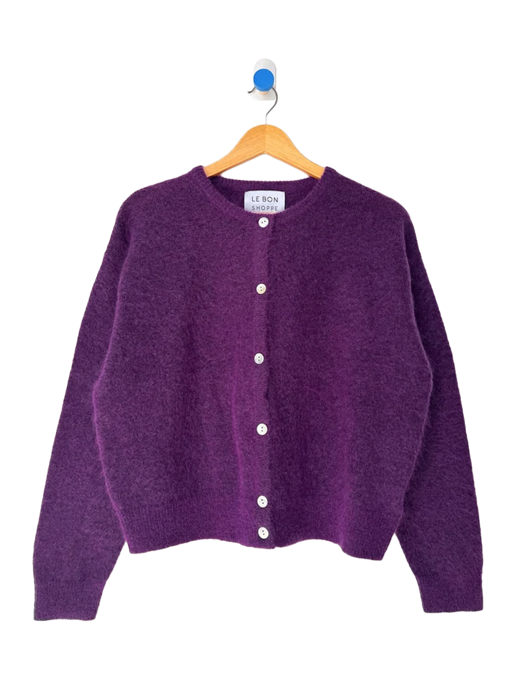 Le Bon Shoppe Ayla Mohair Cardigan in purple displayed on a wooden hanger, featuring a crew neckline and shell button front | Twentyseven Toronto