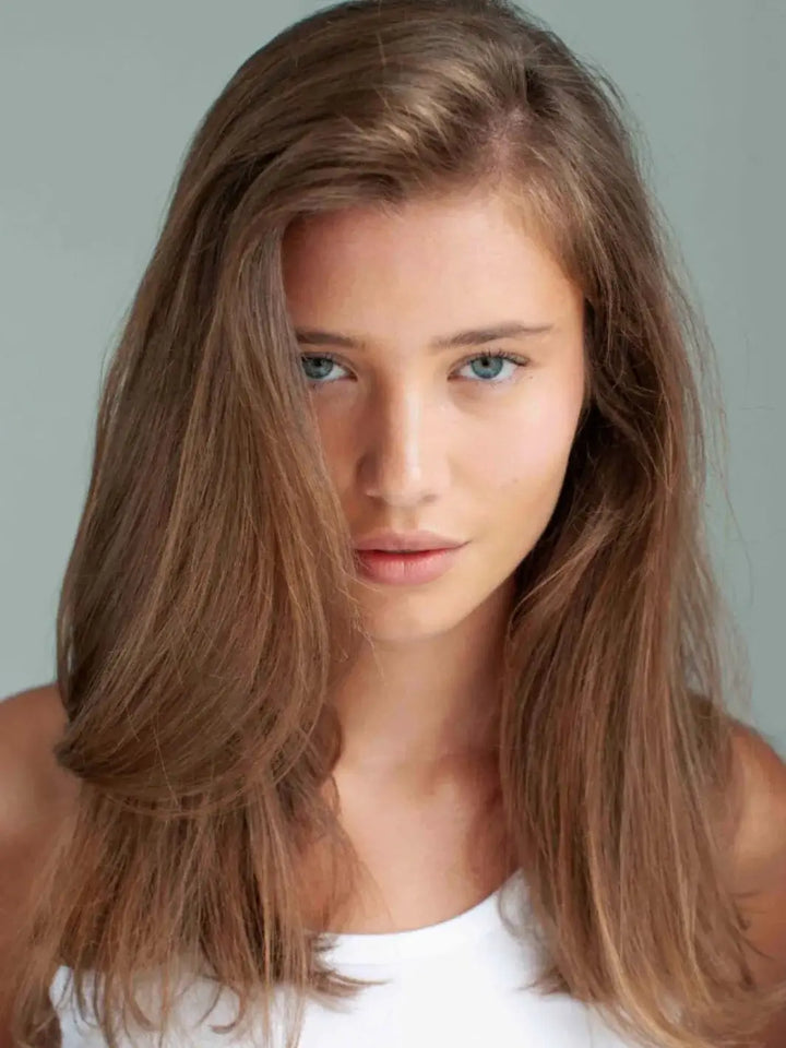 A model with long, light brown hair showcases full-bodied texture and lift achieved with R+Co BALLOON Dry Volume Spray | Twentyseven Toronto