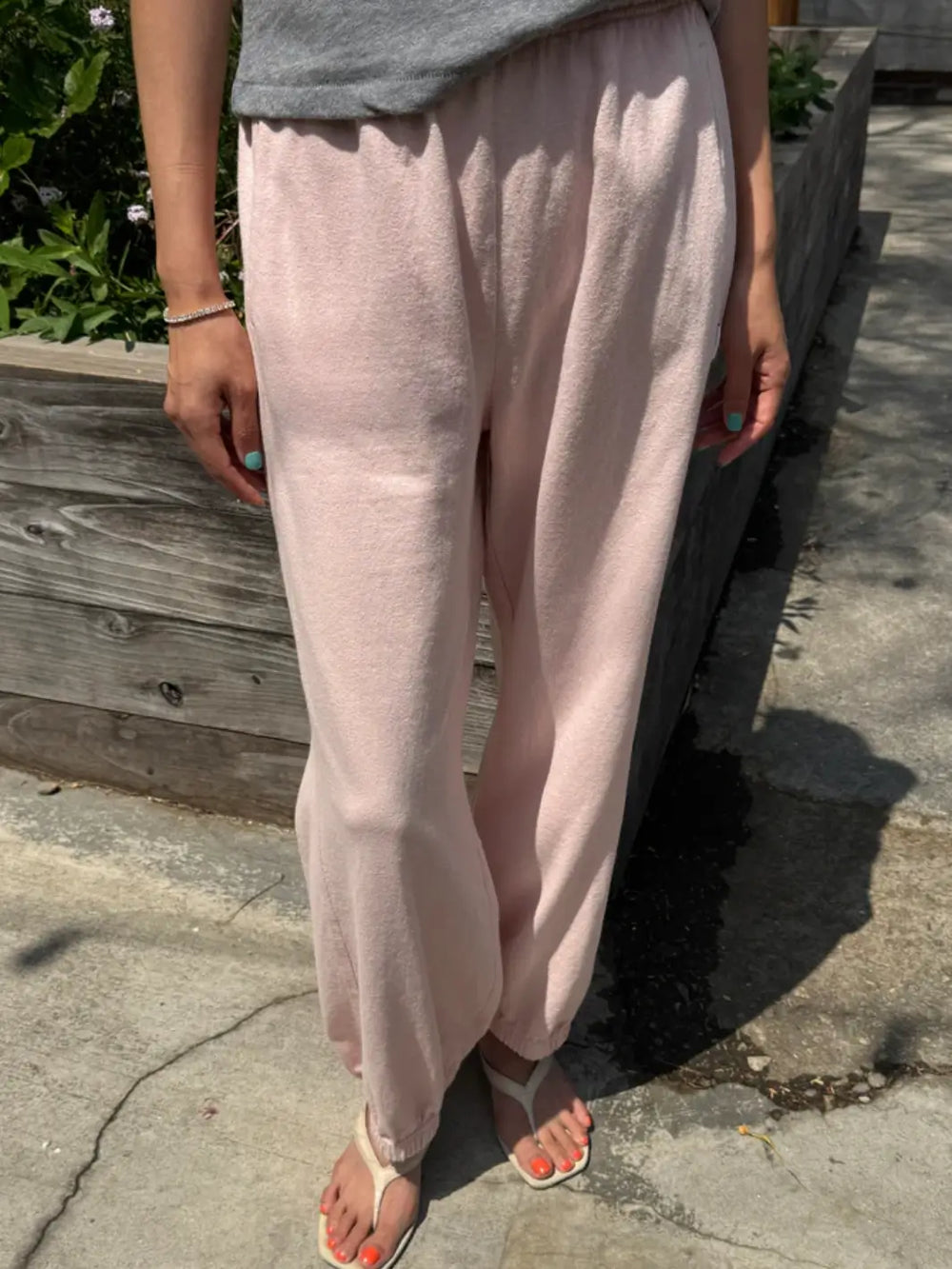 A person models the high-waisted, relaxed-fit Le Bon Shoppe Balloon Pants in Baby Pink with an elastic waistband and cuffs while standing outdoors | Twentyseven Toronto